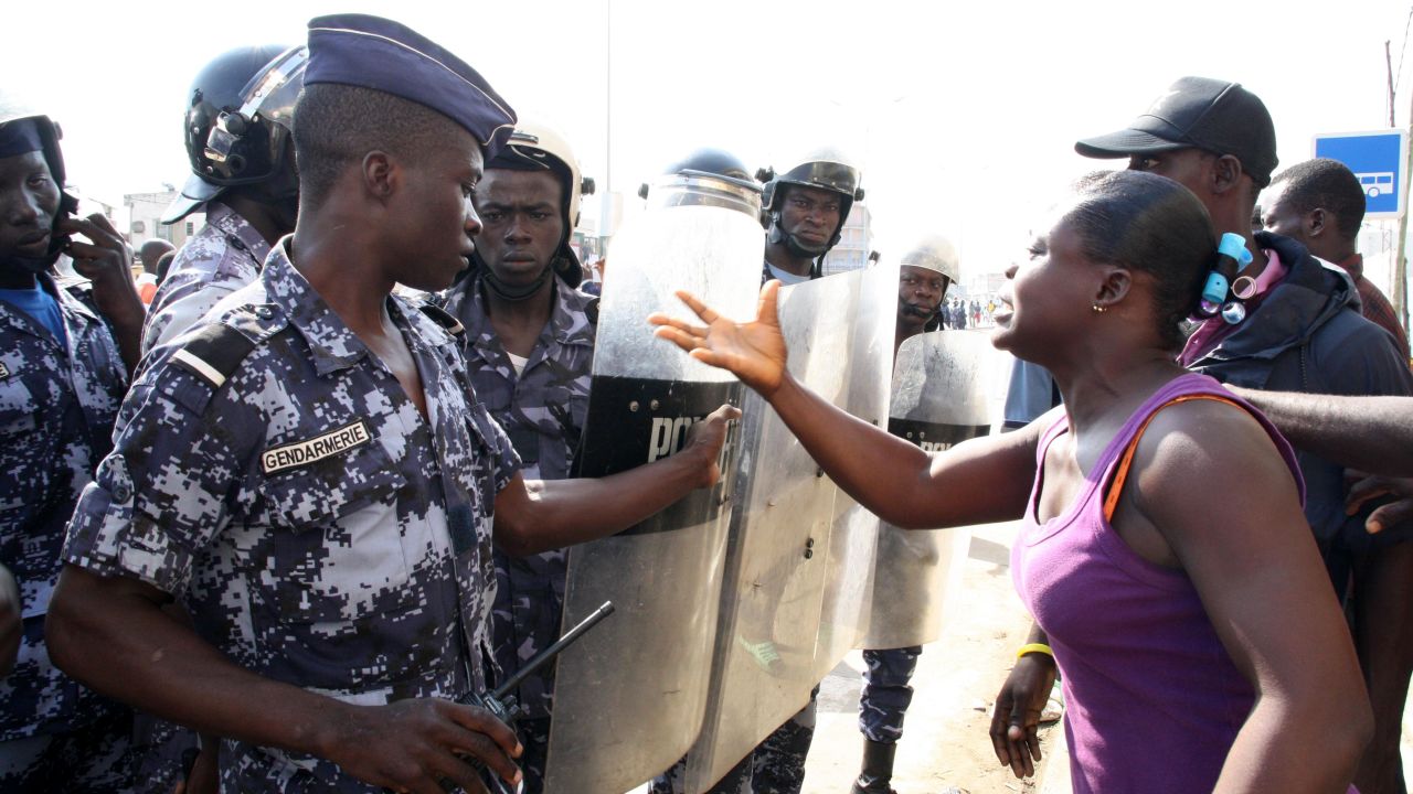 A woman confronts police officers outside a gathering in Lome, Togo, of the opposition group Let's Save Togo.