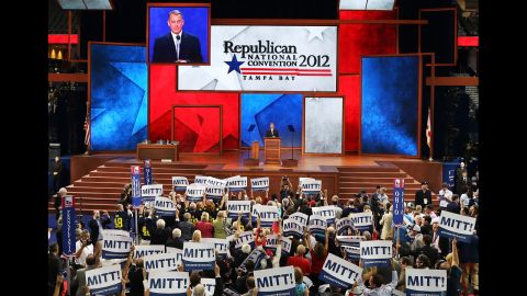 People hold signs that say  "Mitt!" as U.S. Speaker of the House Rep. John Boehner, R-Ohio, speaks.
