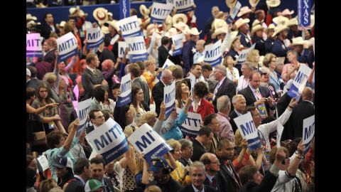 Delegates display signs in support of Mitt Romney after the tallying of votes during the roll call for nomination of president of the United States.