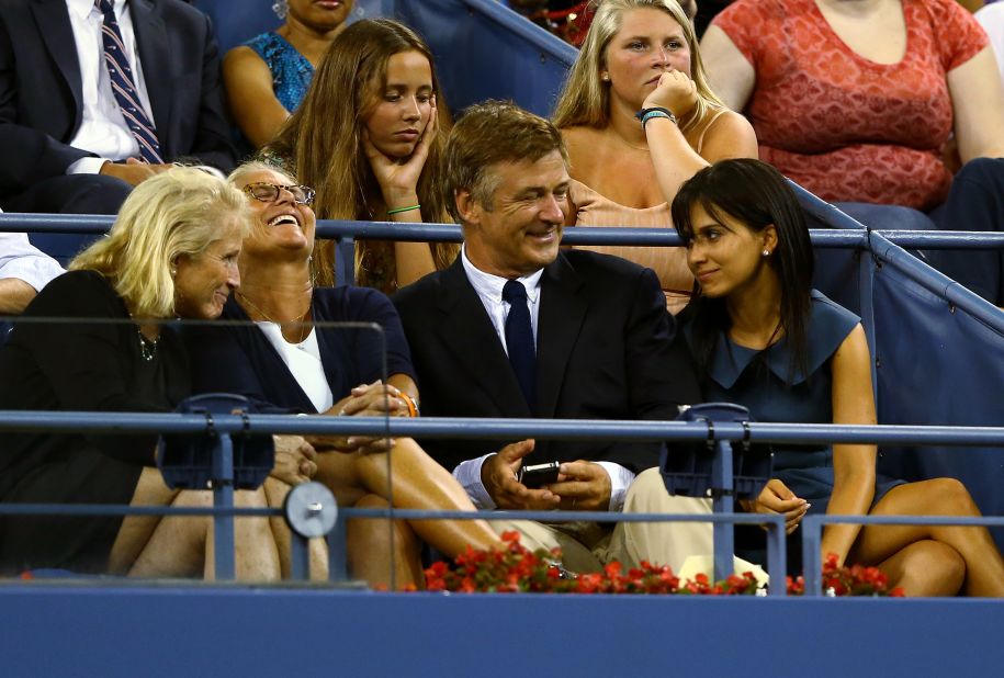 Alec Baldwin, center, and his wife, Hilaria Thomas, right, watch the first day of action Monday at the U.S. Open.