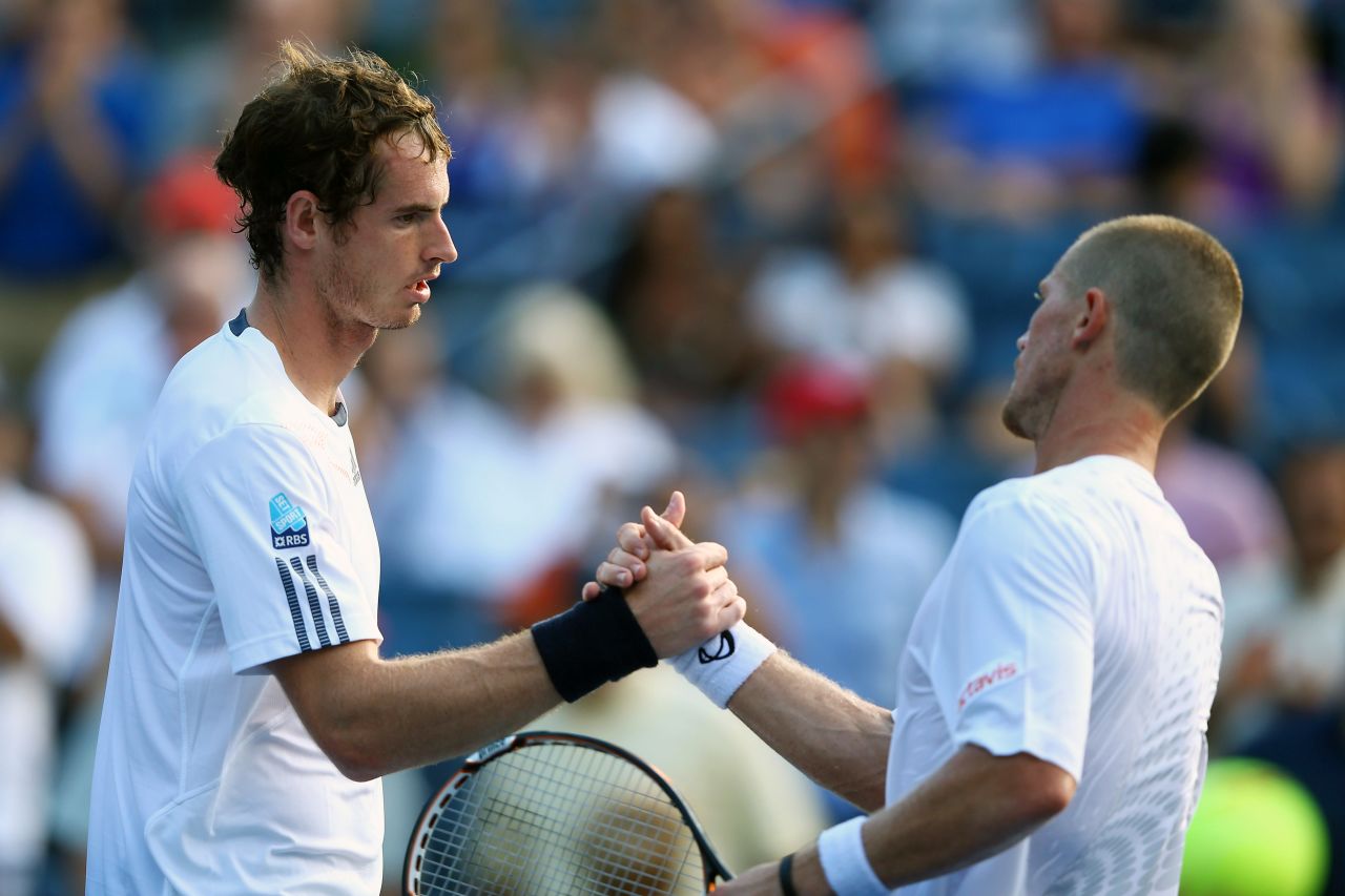 Andy Murray shakes hands at the net with Alex Bogomolov Jr. after winning his men's singles first-round match.