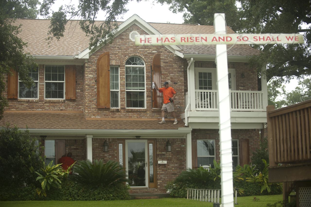 Jason Preston closes shutters on a home in Gulfport, Mississippi, as Hurricane Isaac approaches.