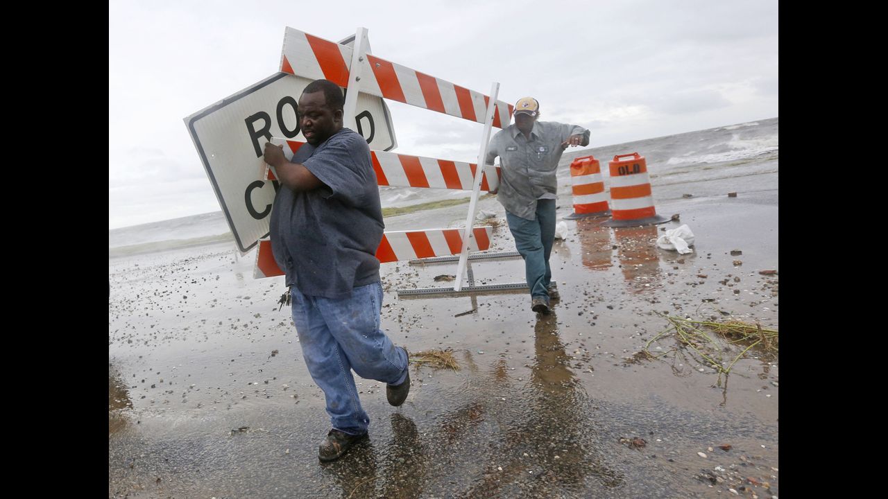Employees of the Orleans Levee District remove signs from Lake Shore Drive near the shore of Lake Pontchartrain. 