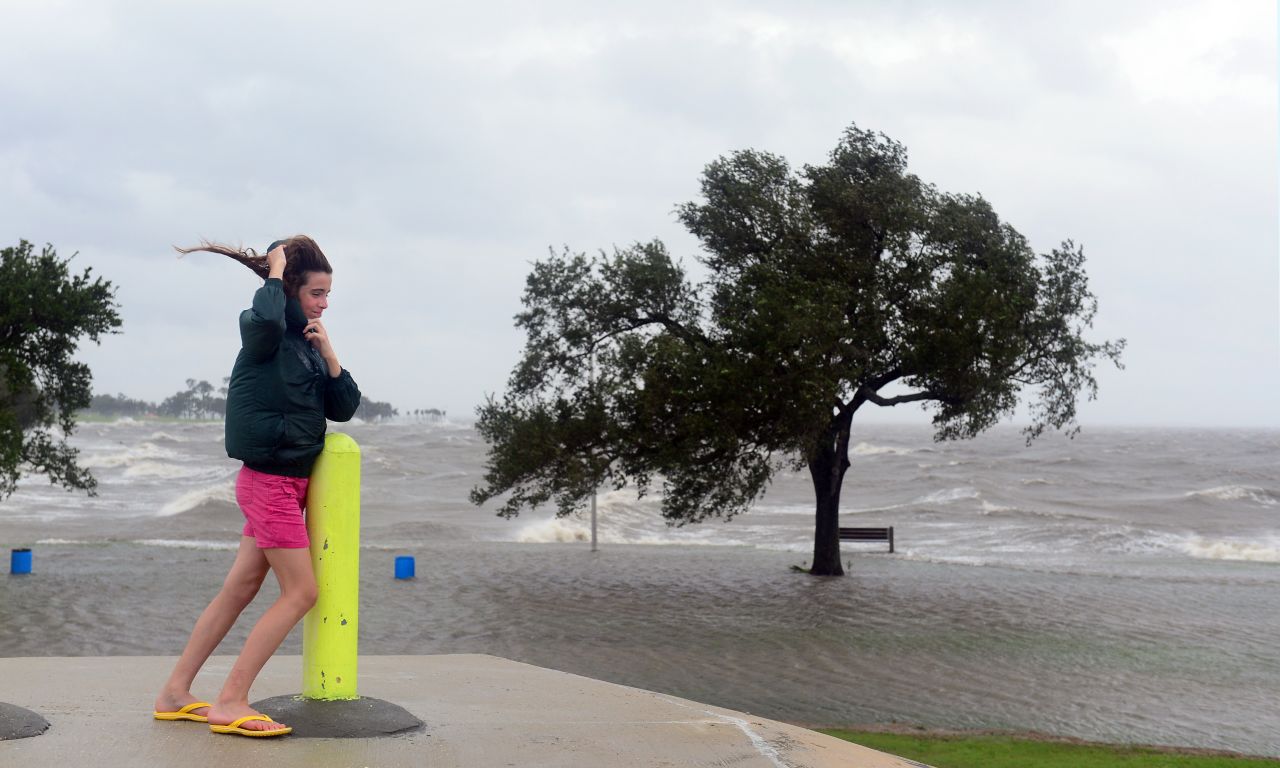 Emily Schneider leans against a pole to support herself against strong winds while visiting the banks of Lake Pontchartrain in New Orleans, where Hurricane Isaac has made landfall.  