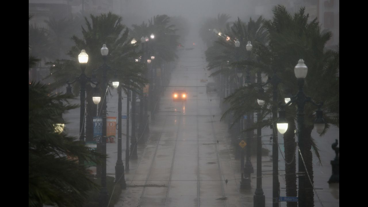 A car drives down Canal Street on Wednesday. The storm is slowly moving across southeast Louisiana, dumping large amounts of rain and knocking out power in scattered parts of the state.