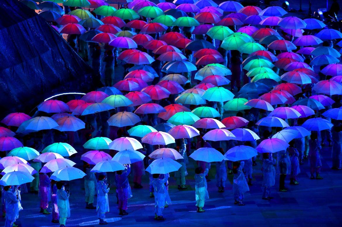 Artists perform with umbrellas.