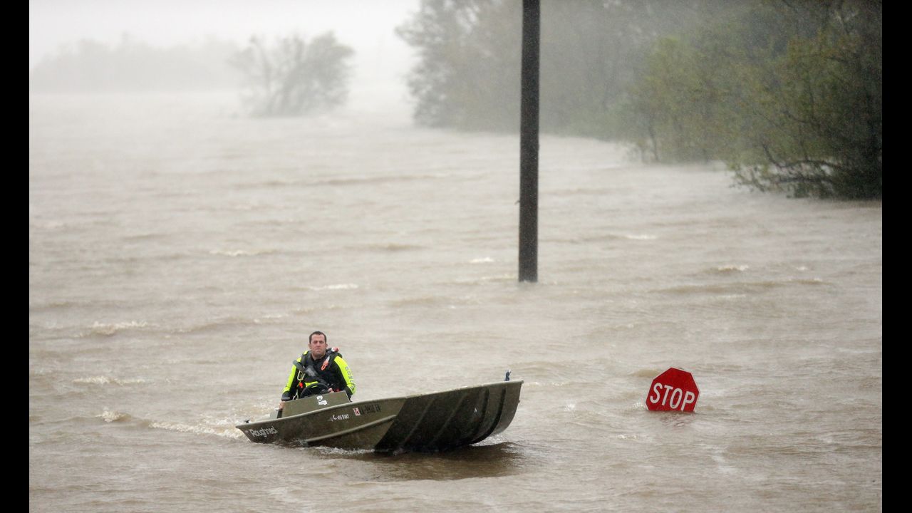 A rescue boat passes a partially submerged stop sign.