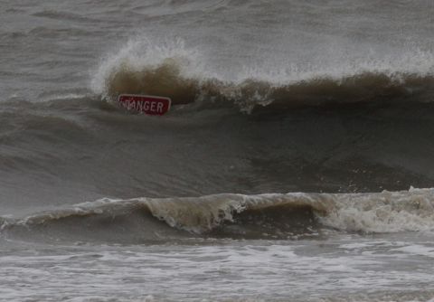 Waves from Hurricane Isaac smash against a warning sign at a flooded beach in Biloxi, Mississippi.