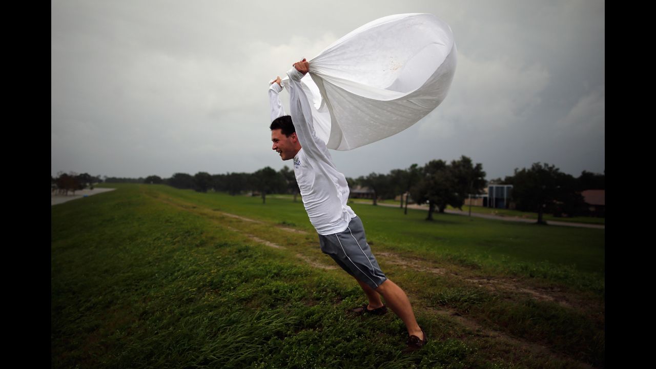 Matthew Pettus holds a sheet open in the wind on the levee near  Lake Pontchartrain.