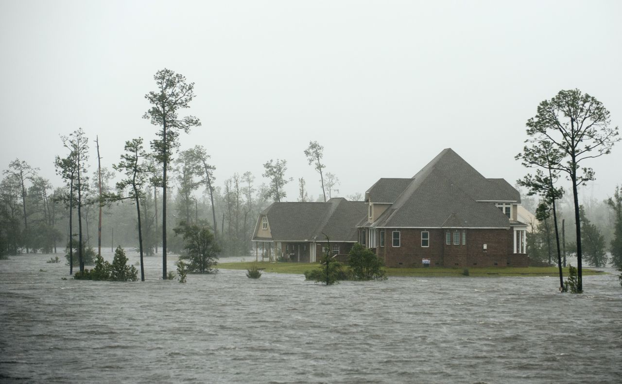 Water surrounds a home on the Jourdan River in Kiln, Mississippi, as Isaac moves through the area.