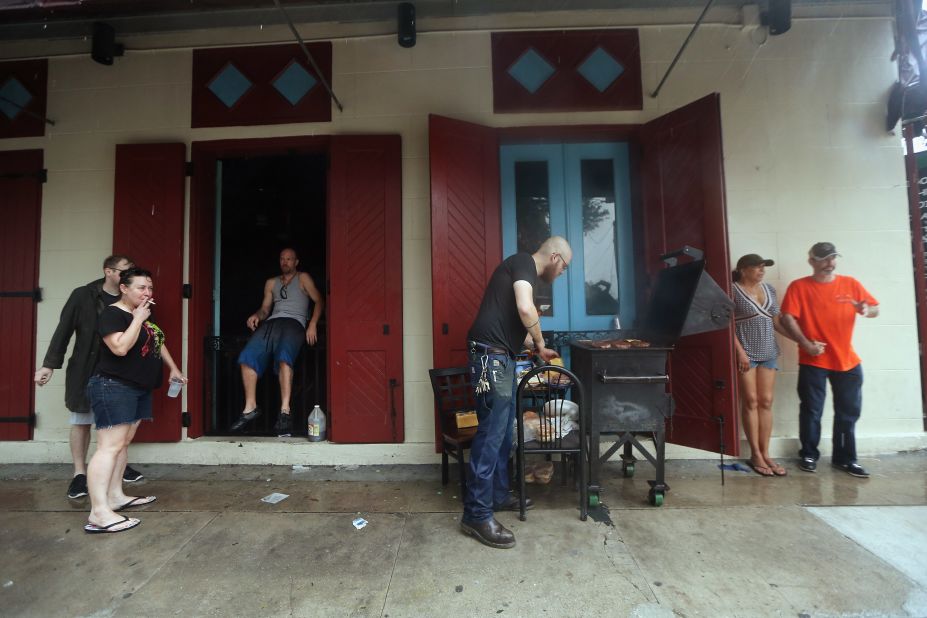 People gather beneath an awning for an impromptu cookout at a bar that lost electricity during Hurricane Isaac in New Orleans.