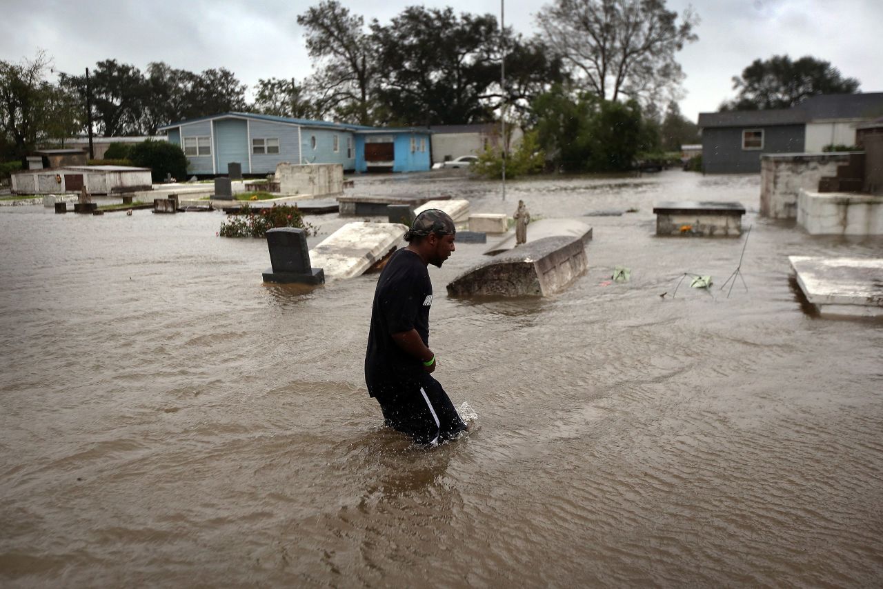 Errol Ragas walks past a cemetery to recover dry blankets from his home as rising waters flood in Oakville, Louisiana. Plaquemines Parish, south of New Orleans, was the area most heavily damaged by the hurricane. 