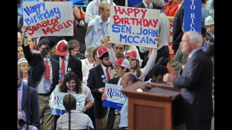 Arizona Senator John McCain speaks to the audience, some of them displaying Happy Birthday posters, during the 2012 Republican National Convention.