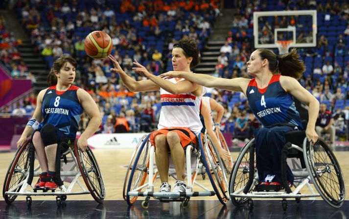 The Netherlands' Inge Huitzing passes the ball as Britain's Laurie Williams, left, and Caroline Maclean defend during the preliminary women's group A wheelchair basketball match.