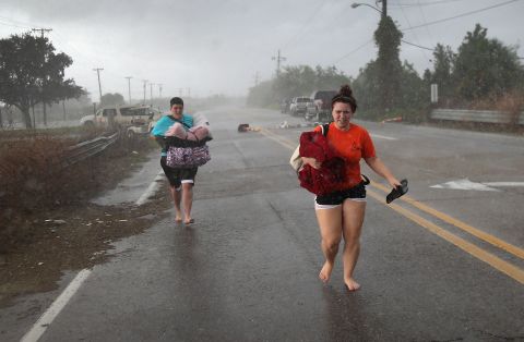 Residents run down a road in Slidell clutching their belongings as they evacuate an area of rising floodwaters from Isaac's rains.