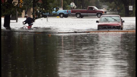 A resident evacuates an area flooded by Hurricane Isaac's storm surge on the north shore of Lake Pontchartrain.