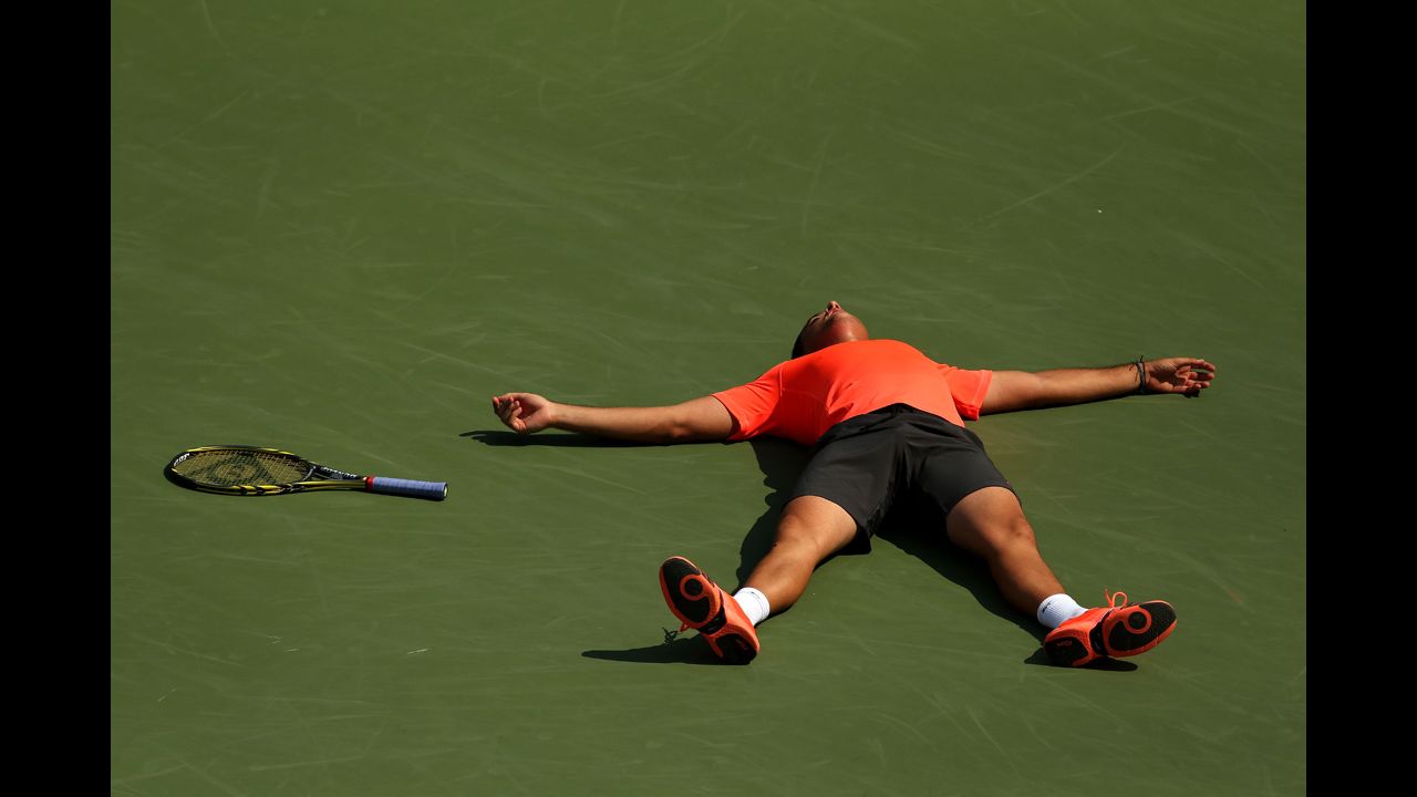 Nicolas Almagro of Spain lies on the court as he celebrates match point after his men's singles second-round match against Philipp Petzschner of Germany.