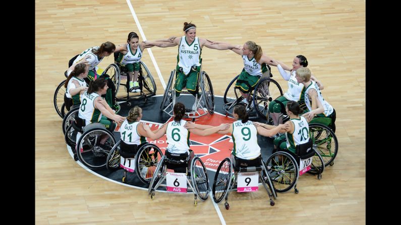 The Australian women's wheelchair basketball team huddles and celebrates their victory during their preliminary basketball game against Brazil.