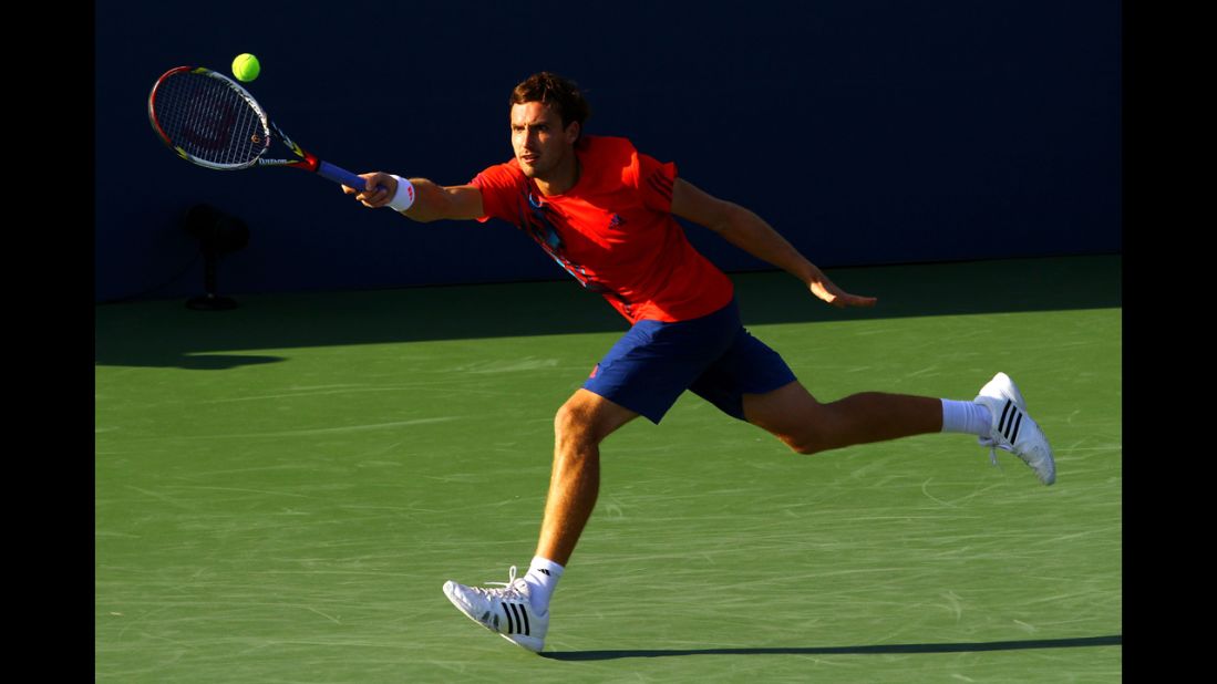 Latvian Ernests Gulbis stretches for the fall during his men's singles first-round match against German Tommy Haas.