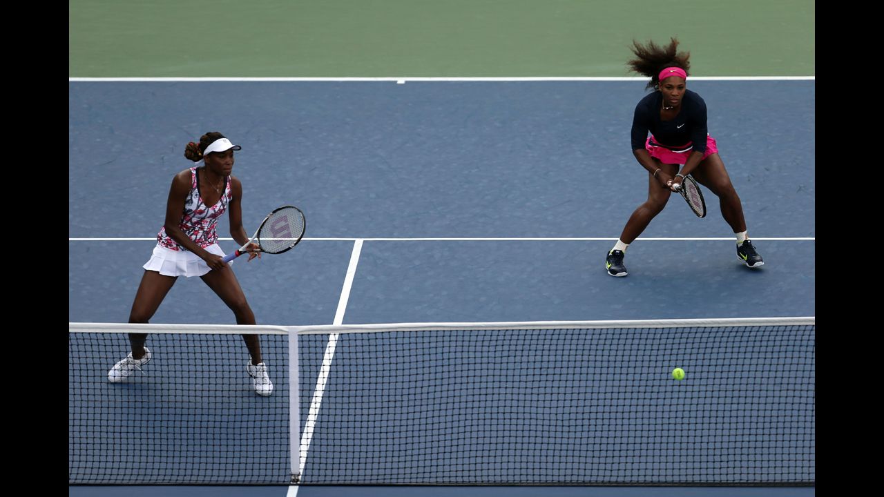 Sisters and doubles partners Venus Williams, left, and Serena Williams of the U.S. take on U.S. players Mallory Burdette and Nicole Gibbs during their women's doubles first-round match.