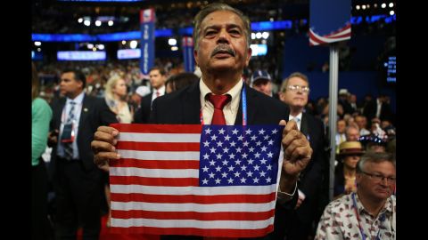 A man holds an American flag in the audience.