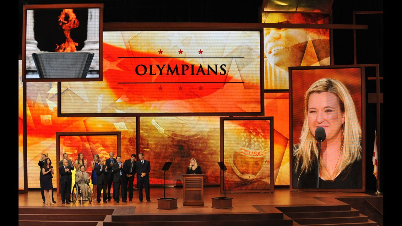 Olympians and gold medalists Michael Eruzione, Derek Parra and Kim Rhode stand on stage at the convention.