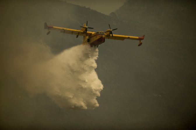 A fire brigade plane pours water to extinguish a wildfire in Ojen on August 31, 2012. 