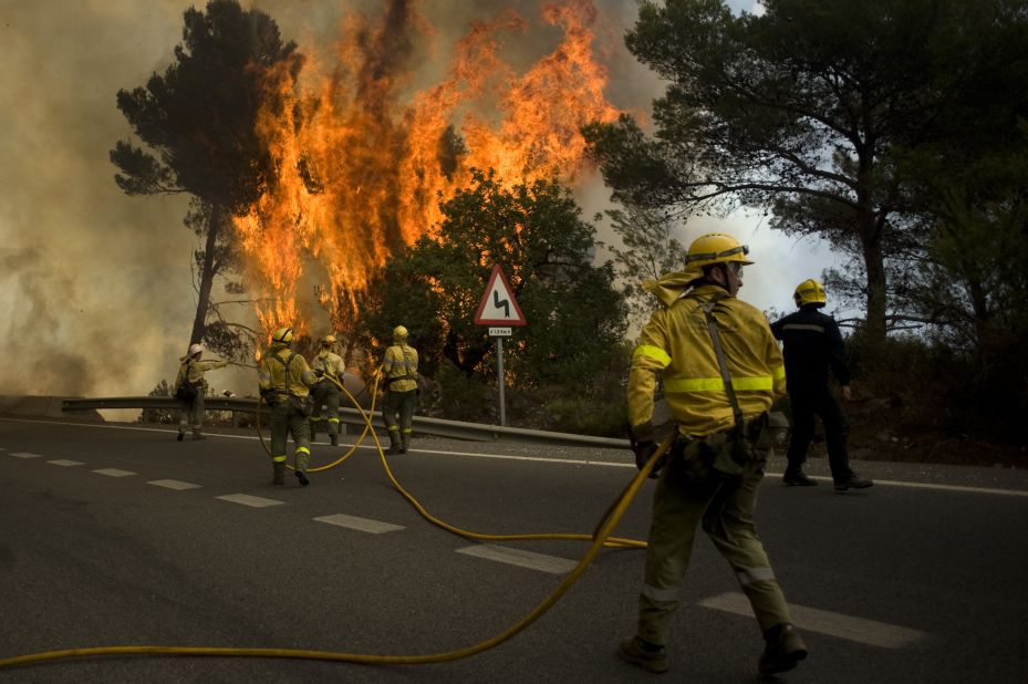 Firefighters try to extinguish wildfires in Ojen, near the town of Malaga, on August 31, 2012. More than 250 firefighters on the ground, backed by eight planes and nine helicopters in the air, battled the blaze after hot, dry winds sent it racing through tinder-dry forest in southern Spain. 