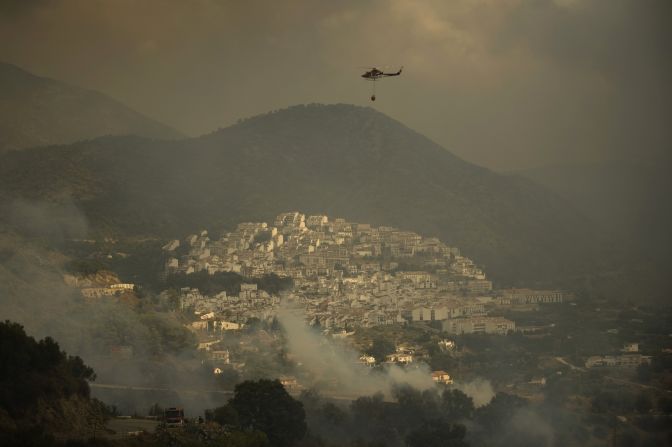 A fire brigade helicopter prepares to pour water to extinguish a wildfire in the village of  Ojen on August 31, 2012. Some 4,000 people have been evacuated from the area with an additional 2,000 evacuated from the eastern part of Marbella.
