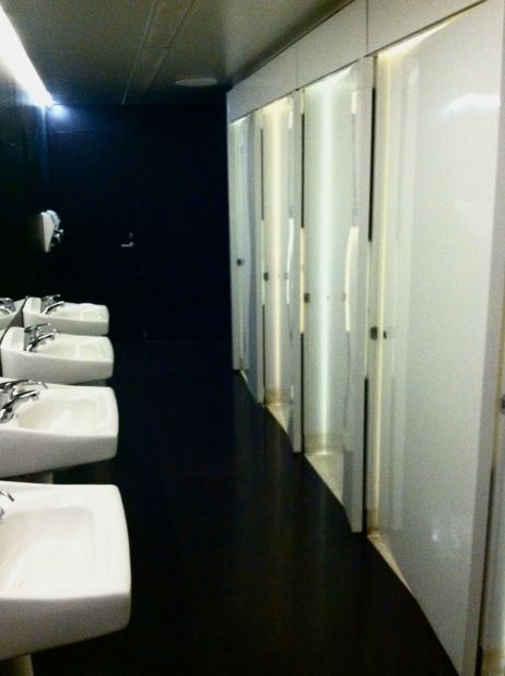 Glossy white doors contrast dramatically with black walls in the Walker Art Center's sleek restrooms.