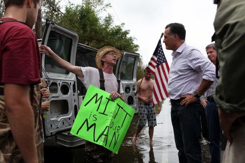 Republican presidential candidate Mitt Romney  talks with a man on the side of the road while on an unscheduled tour of a neighorhood damaged by Isaac on Friday, August 31, in Lafitte, Louisiana. 