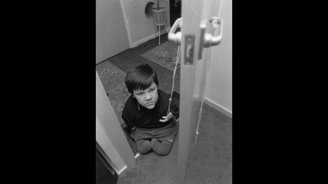 Eddie Freeman, 13, opens a door with a piece of string in this 1973 image.
