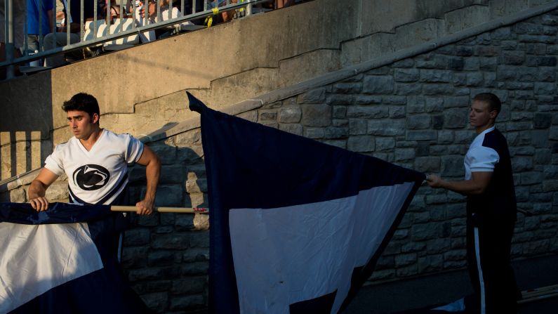 Cheerleaders prepare flags prior to the start of the pep rally.