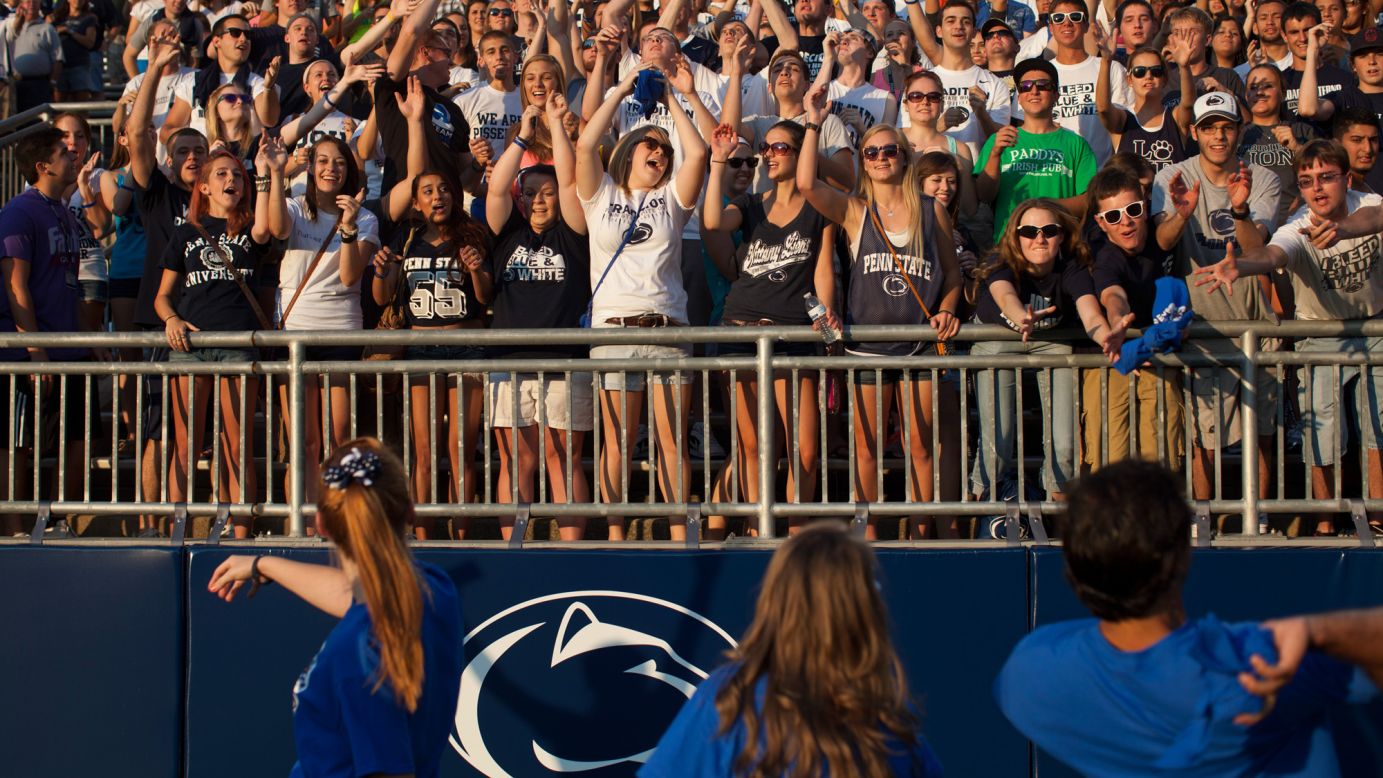 Penn State football fans grab for T-shirts thrown into the stands at Beaver Stadium.