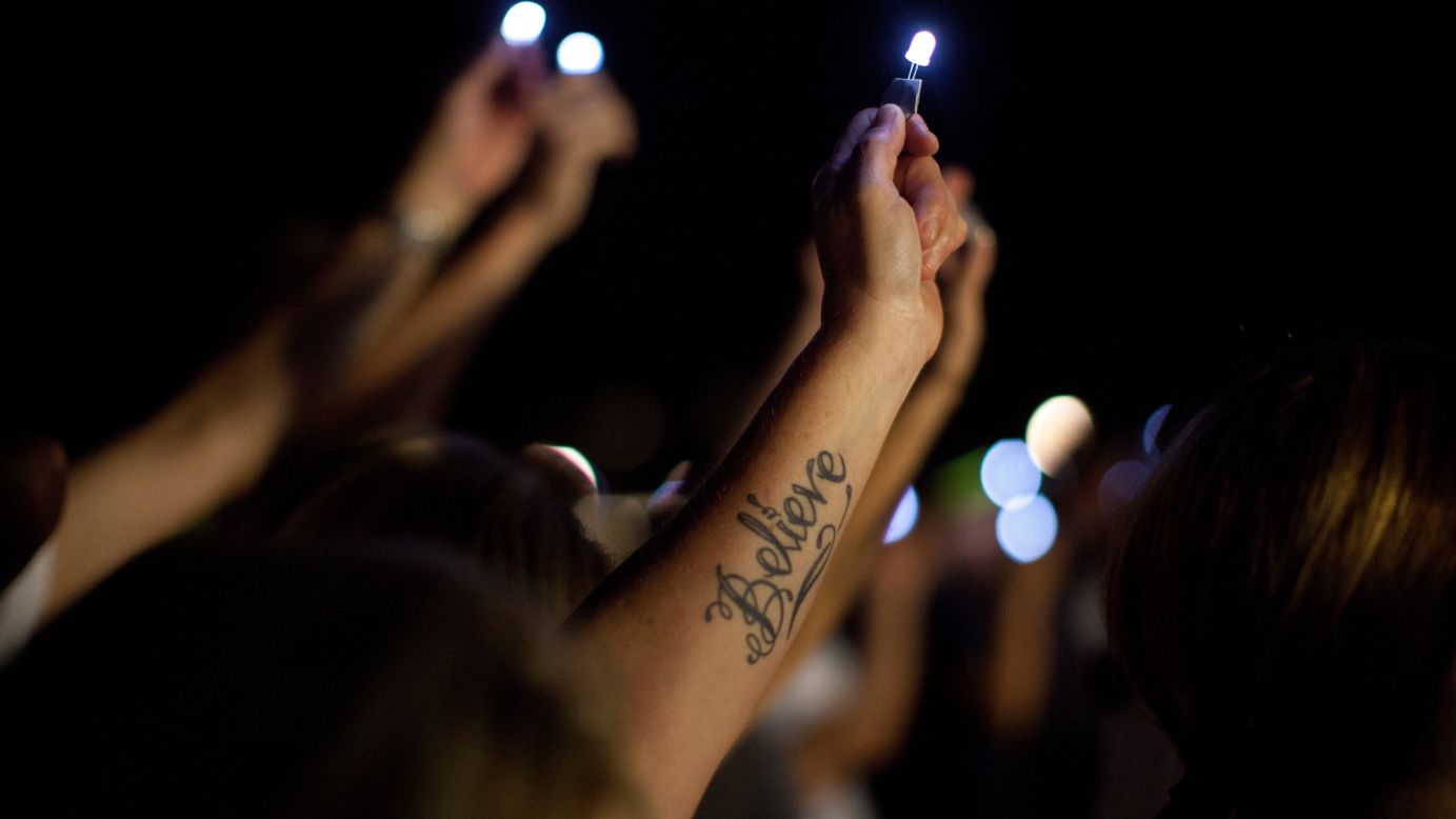 Penn State employee Debbie McKinley raises her light during a prayer at the White Out Prayer Vigil on campus.