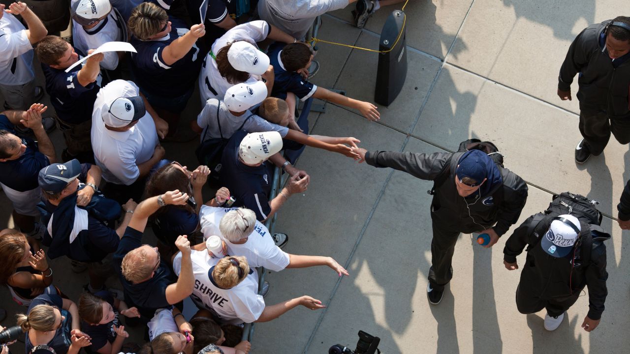 Penn State fans greet members of the football team as they arrive at the stadium.