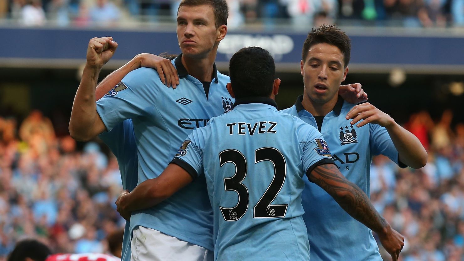 Carlos Tevez celebrates with goalscorer Edin Dzeko and Samir Nasri in Manchester City's 3-1 win over QPR. 