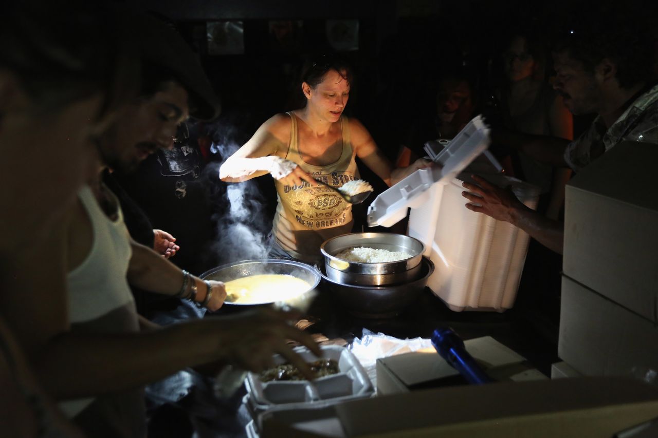 Local residents serve up chicken etouffee and rice delivered by the Louisiana National Guard at JJ's Bar in the Bywater neighborhood of New Orleans. The military gave out the food to residents of the area, which was still without electricity three days after Hurricane Isaac knocked out power to hundreds of thousands of people.