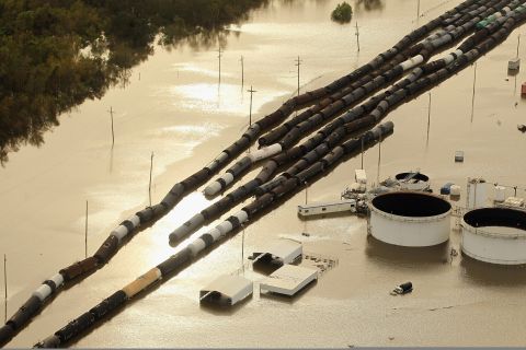 Oil containers and railroad cars sit in Isaac's flood waters in Braithwaite, Louisiana. 