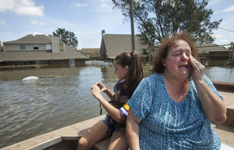 Plaquemines Parish resident Angela Serpas reacts after seeing her flooded home for the first time following Hurricane Isaac, as her daughter Lainy takes pictures, in Braithwaite, Louisiana, on Saturday, September 1.