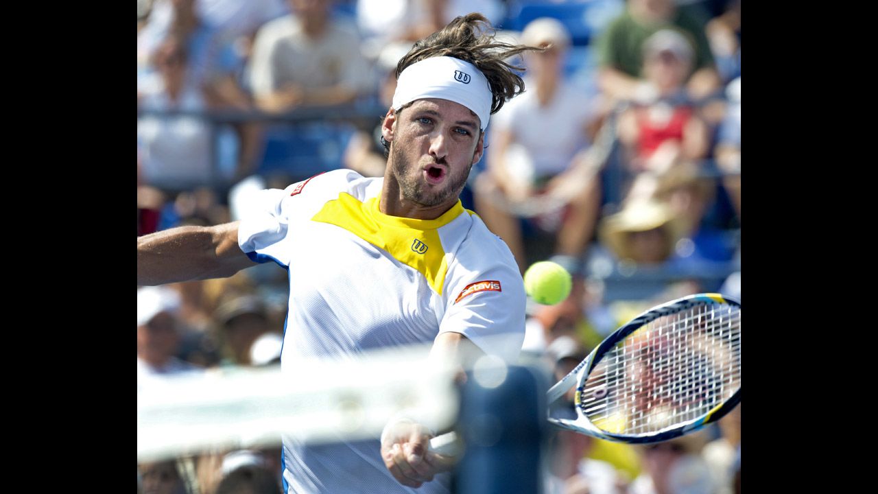 Spain's Feliciano Lopez of Spain hits a return to Andy Murray of Great Britain.