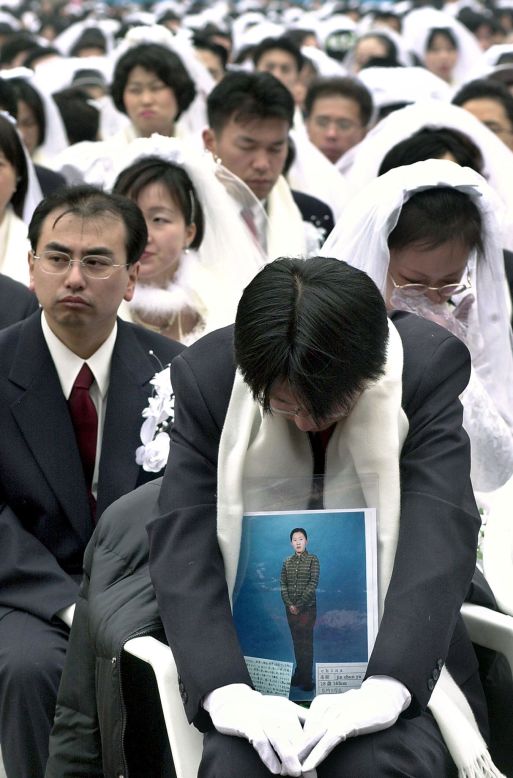 A Japanese devotee holds a portrait of his bride, who couldn't join in the mass wedding event at the Olympic Stadium in Seoul on February 13, 2000. Moon married some 30,000 couples at the event.