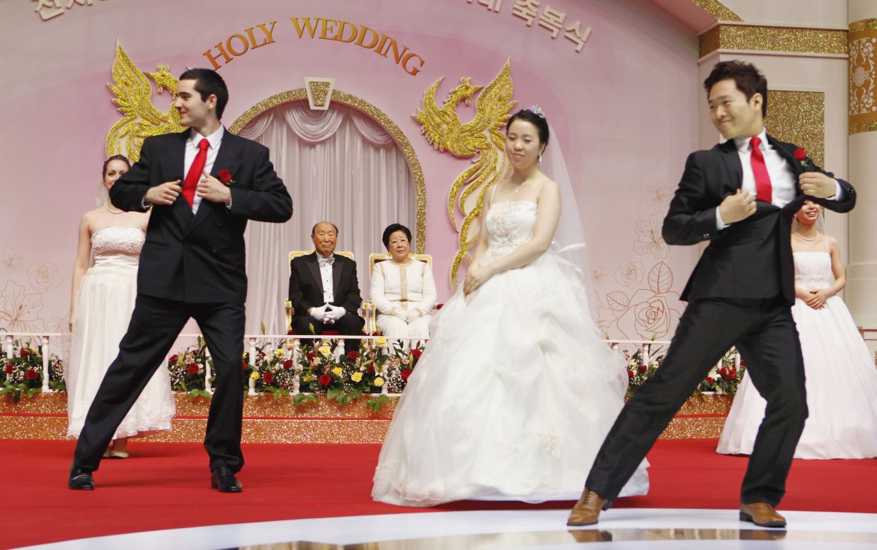 Moon and his wife, Hak Ja Han, watch the newly married couples dance a waltz.