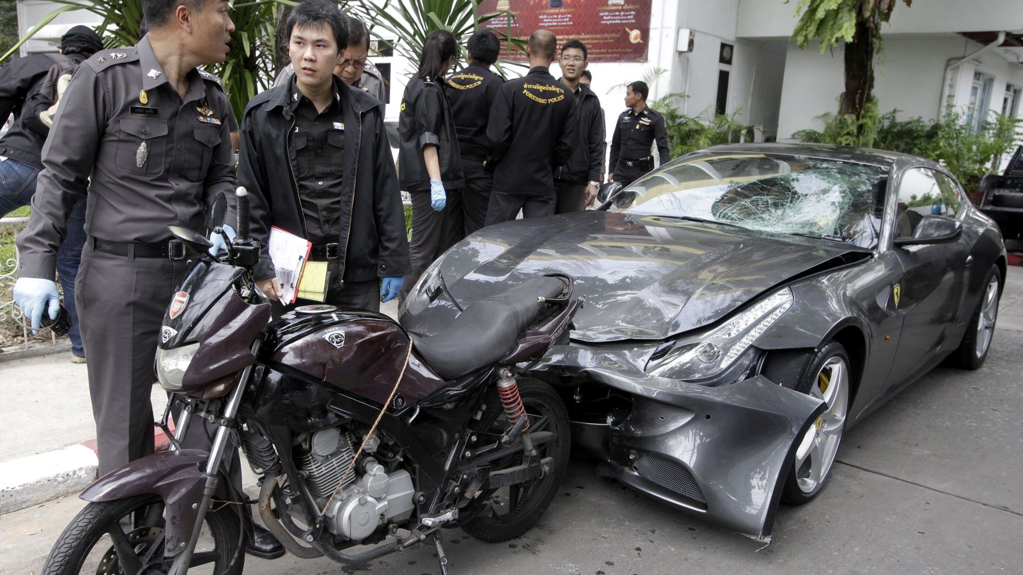 Thai police officers inspect a Ferrari owned by Vorayuth Yoovidhya in Bangkok, in September 2012.