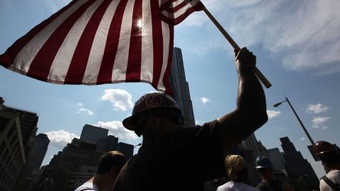  A union worker carries an American flag across the Brooklyn Bridge during a March for the Middle Class In June 2011.