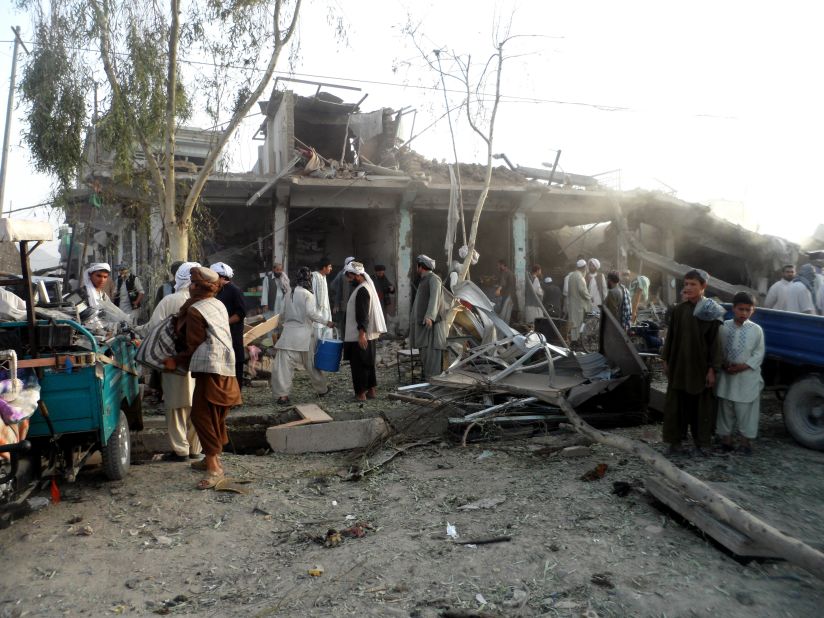 Afghans observe the scene of a recent car bombing in Kandahar. The police chief, Gen. Abdul Raziq, was among 16 people injured in the attack on August 28. Four people were killed.