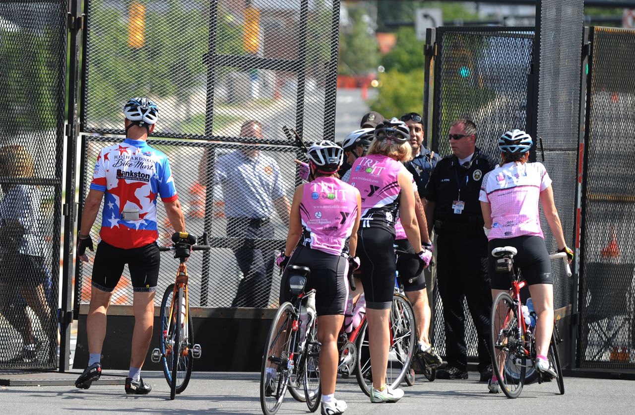Bicycle riders are stopped by police guarding the perimeter of the Time Warner Cable Arena on Monday.