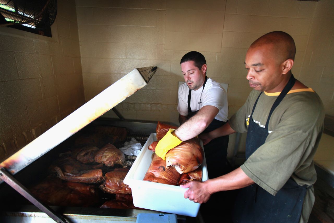 Bill Spoon's BBQ employees remove pork from a smoker at the nearly 50-year-old restaurant known for its Eastern North Carolina Style BBQ. The restaurant was recently recovnized as one of the 10 best BBQ restaurants in the United States. The state is expecting $150 million to $200 million economic impact from the DNC. 
