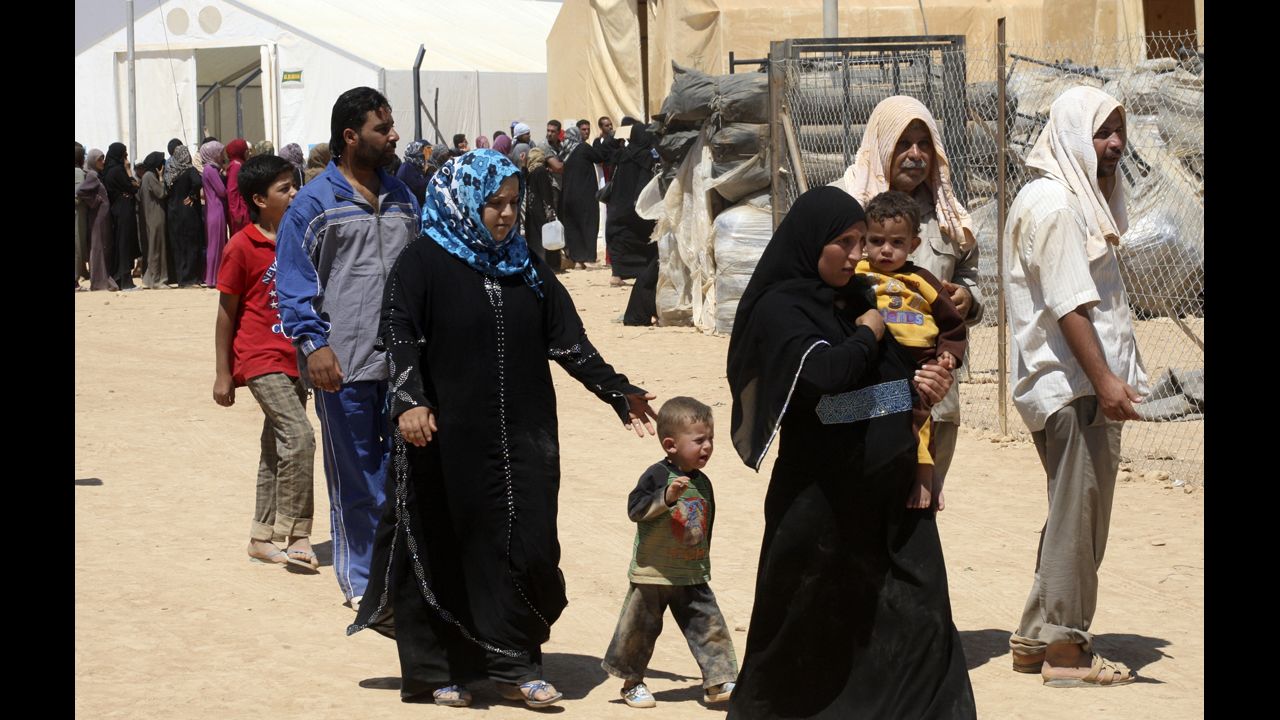 Syrian refugees walk through the camp. 