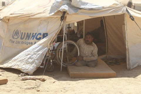 A handicapped Syrian refugee looks out of his tent. Za'atari Camp was built on a barren desert plain without a tree or shrub in sight. Severe sandstorms and scorching heat have taken their toll on refugees and aid workers here.